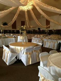 the banquet room is set up with white linens and gold sashes