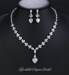 a necklace and earring set on a mannequin headpiece with crystal stones