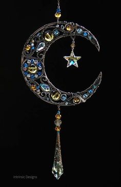 the moon and star is hanging from a chain with crystal beads on it's side