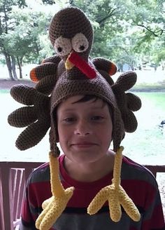 a young boy wearing a knit turkey hat