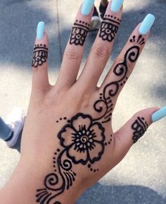 a woman's hand with hendix and flowers on it, painted blue