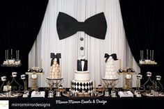 a black and white dessert table topped with lots of cake