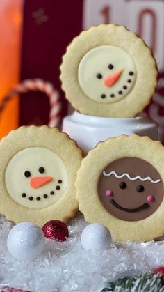 three decorated cookies sitting on top of snow