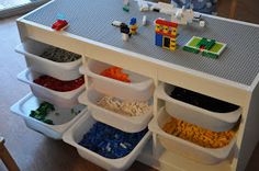 a toy kitchen with legos on the counter and food in bins under it