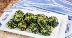 spinach balls on a white plate sitting on a blue and white towel