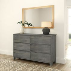 a dresser with a mirror and vase on top