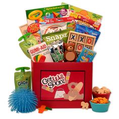 a red box filled with lots of toys and snacks on top of a white surface