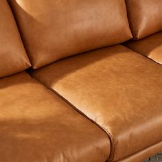 a brown leather couch sitting on top of a carpet