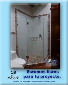 a bathroom with a glass shower door and tile flooring on the walls is shown