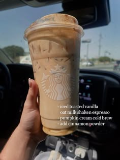 someone holding up a cup of coffee in their hand with the caption, iced roasted vanilla out milkshake espresso pumpkin cream cold brew add cinnamon powder