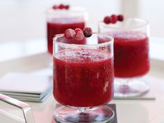 two glasses filled with raspberry juice on top of a table