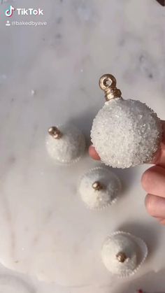 someone is holding some small white balls in their hand and they are all covered with snow