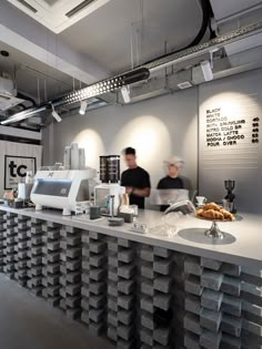 two people standing behind a counter in a restaurant