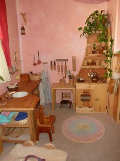 an old fashioned kitchen with pink walls and wooden furniture