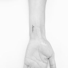 a person's hand with a small tattoo on it