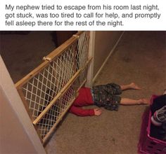 a little boy laying on the floor next to a cage