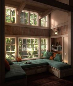 a living room filled with lots of windows next to a green couch and coffee table