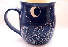 a coffee cup with an image of the moon and stars on it's side