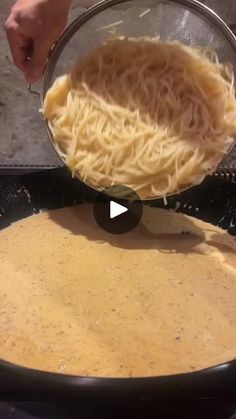 someone is mixing pasta in a pan on the stove