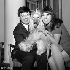 the man and woman are posing with their dog