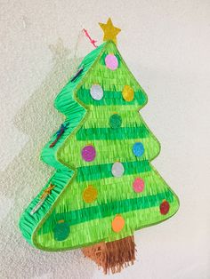 a paper plate christmas tree hanging on the wall