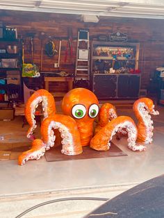 an orange octopus statue sitting on top of a garage floor