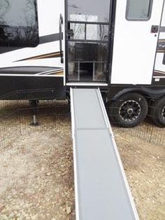 an rv parked on the side of a road with its door open and ramp attached to it