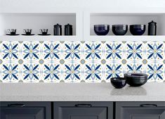 a kitchen counter with blue and white tiles on it