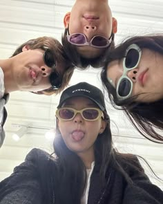 four girls wearing sunglasses are standing in a circle