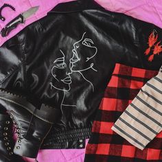 Flat lay of black leather jacket with faces painted on the back, paired with red dragon earrings, red plaid mini skirt, striped polo, and platform doc martens boots. Drawn Faces, Tall Socks, Black Vegan, 90s Style, Black Leather Jacket