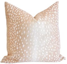 a beige and white pillow with spots on it