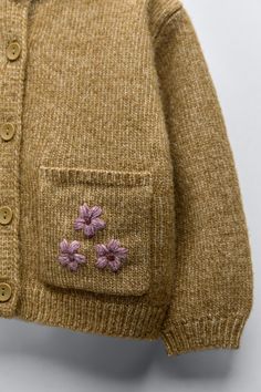 a close up of a sweater with flowers on it