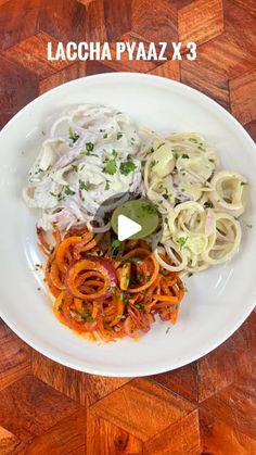 a white plate topped with pasta and onions on top of a wooden table next to a knife