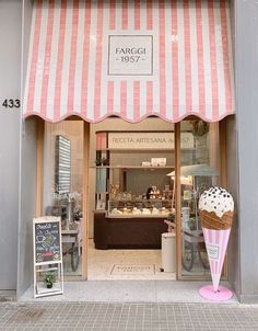 an ice cream shop with pink and white striped awning