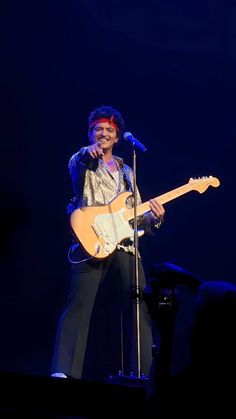 a man that is standing up with a guitar