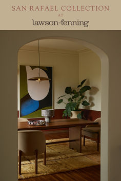 an archway leading into a living room with a painting on the wall