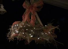 a christmas wreath hanging from the ceiling with lights