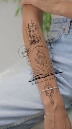 a person with a tattoo on their arm sitting down and holding a cell phone in her hand