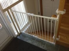 an open door with a white railing on the front of a house next to a doorway