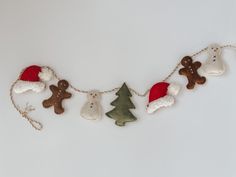 a christmas garland with teddy bears and snowmen hanging from it's sides on a white wall