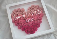 a heart made out of rolled flowers in a white frame with the words wedding date printed on it