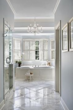 a white bathroom with a chandelier and tub