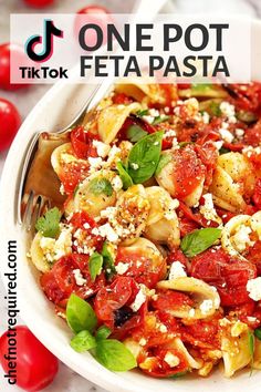 one pot feta pasta with tomatoes and basil in a white bowl on a marble surface