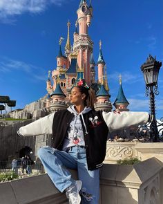 a woman poses in front of a castle