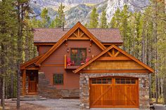 a large brown house surrounded by trees and mountains