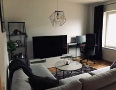 a living room filled with furniture and a flat screen tv on top of a wall