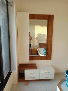 a bathroom with a sink, mirror and drawers on the floor next to a window