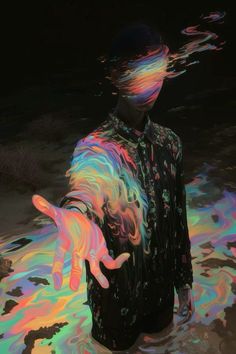 a man is standing in the water with his hands out to touch something multicolored