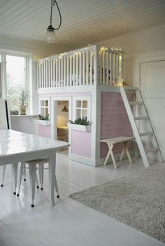 a loft bed is built into the side of a pink and white house with stairs leading up to it