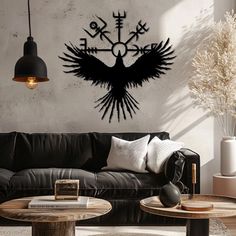 a living room filled with furniture and a large black bird wall decal on the wall